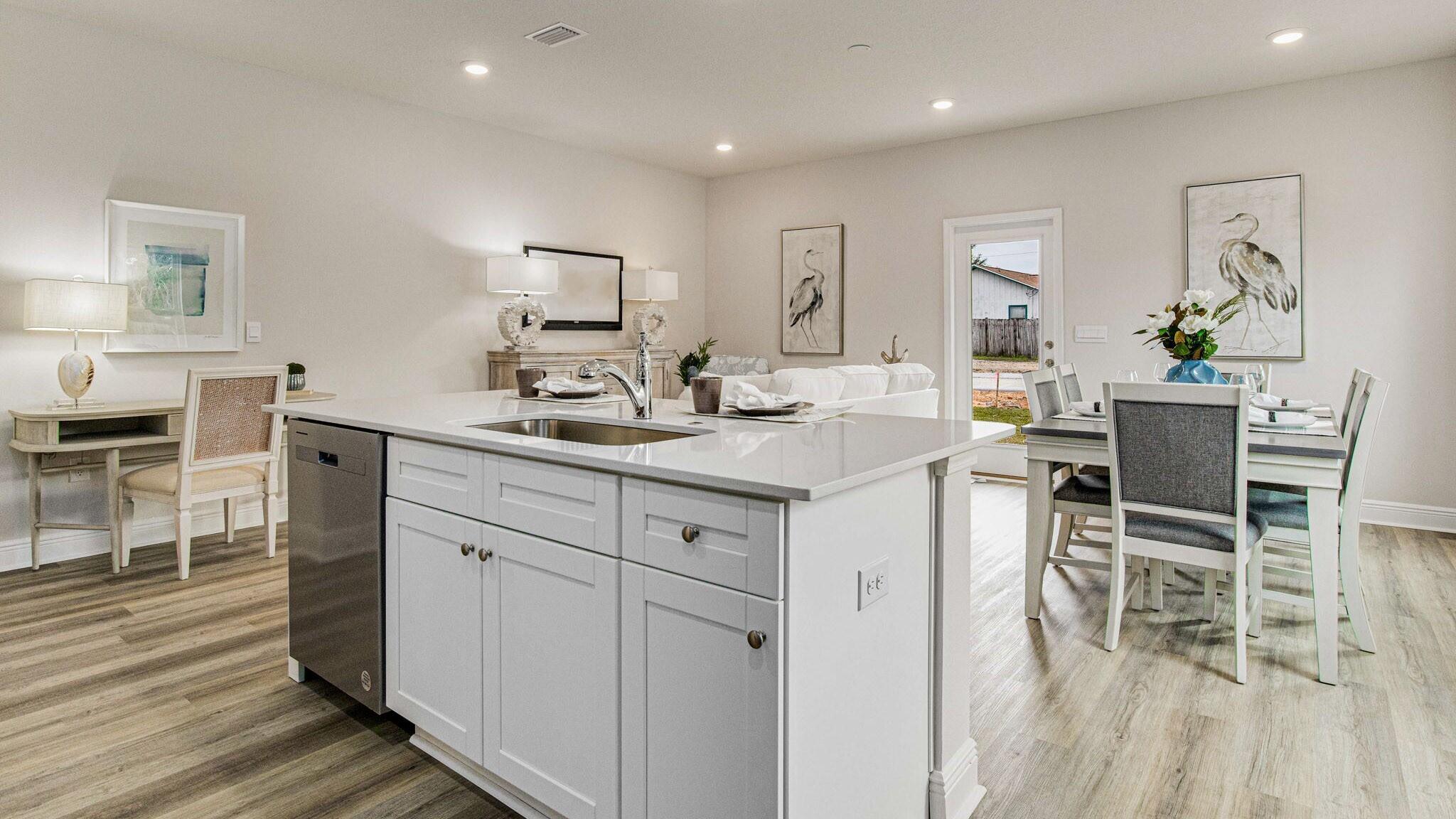 8553 Midtown Court Navarre, FL 32566 - Photo 5 of 27 a kitchen with a sink chairs and wooden floor