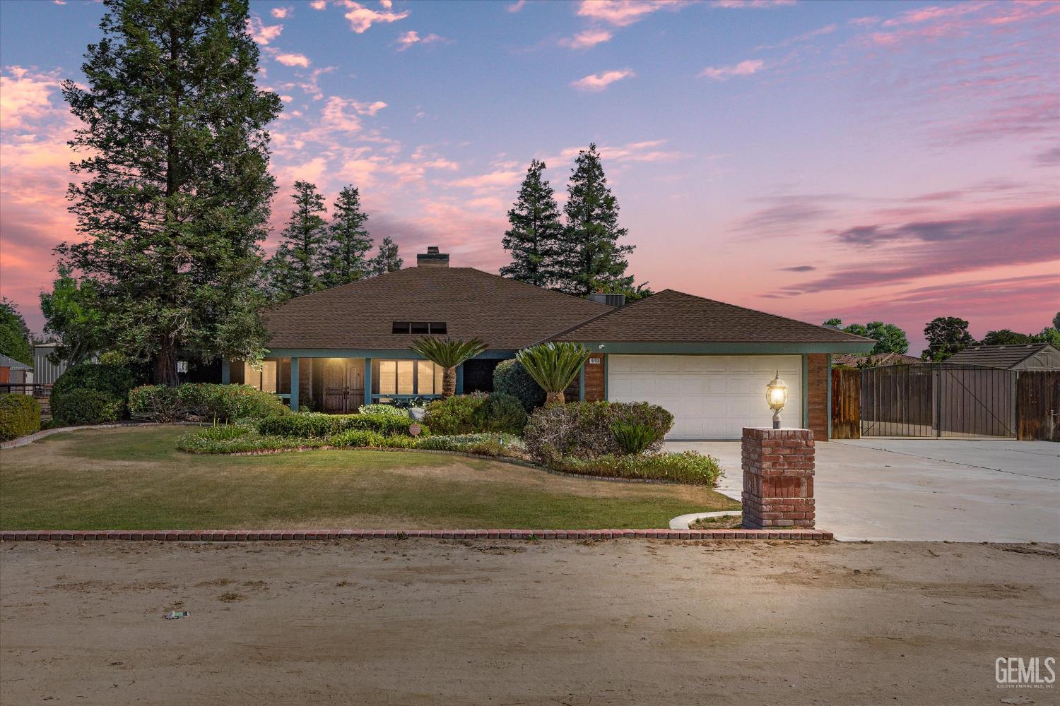 Undisclosed Address Bakersfield, CA 93314 - Photo 1 of 69 a front view of a house with a yard and garage