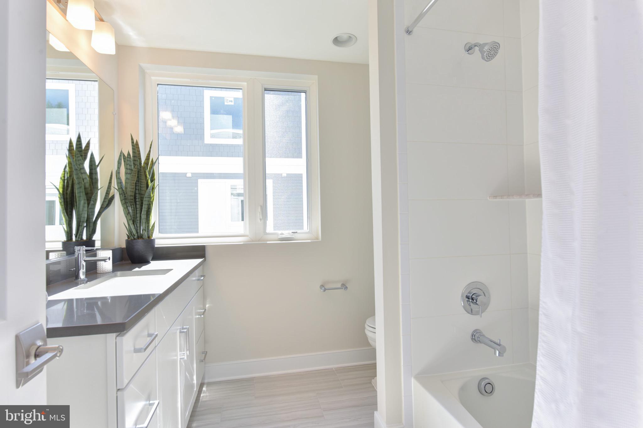2823 24th Road South Arlington, VA 22206 - Photo 17 of 97 a bathroom with a granite countertop sink a mirror and a bathtub