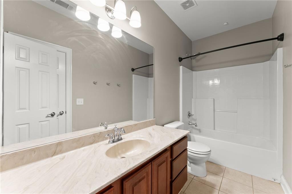6643 Windvane Point Clermont, GA 30527 - Photo 47 of 88 a bathroom with a granite countertop sink a toilet and shower