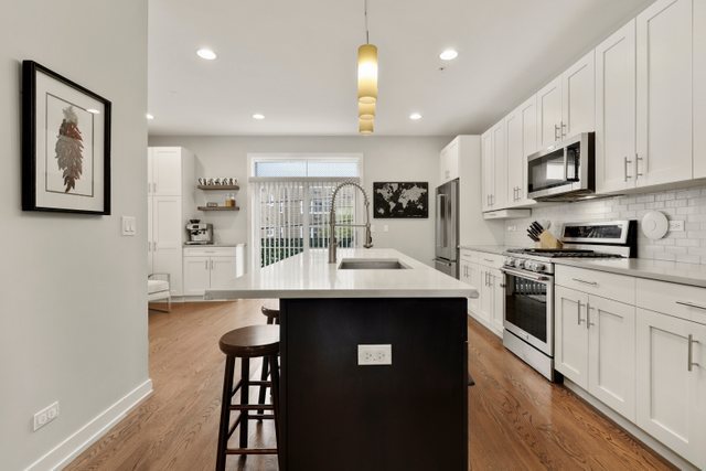 1027 Walnut Way Oak Park, IL 60302 - Photo 11 of 35 a kitchen with stainless steel appliances granite countertop a sink a stove top oven a counter space and cabinets