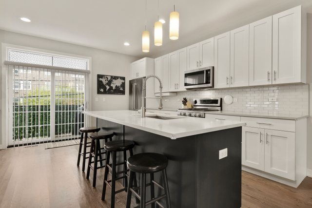 1027 Walnut Way Oak Park, IL 60302 - Photo 10 of 35 a kitchen with stainless steel appliances granite countertop a table chairs sink and cabinets