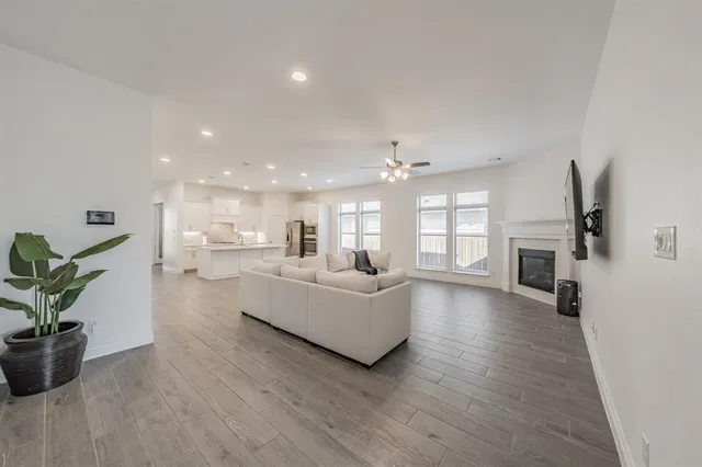 a view of white house with wooden walls and potted plants