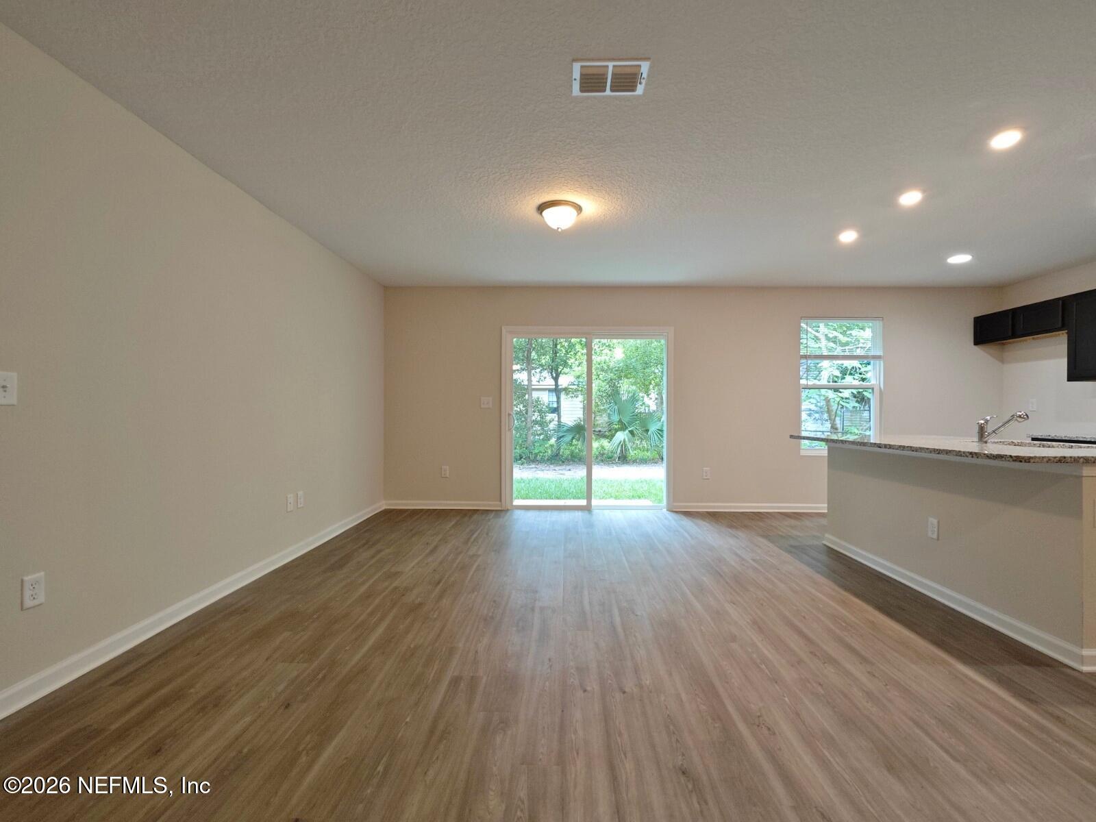3142 Rosselle Street Jacksonville, FL 32205 - Photo 4 of 7 an empty room with wooden floor and windows