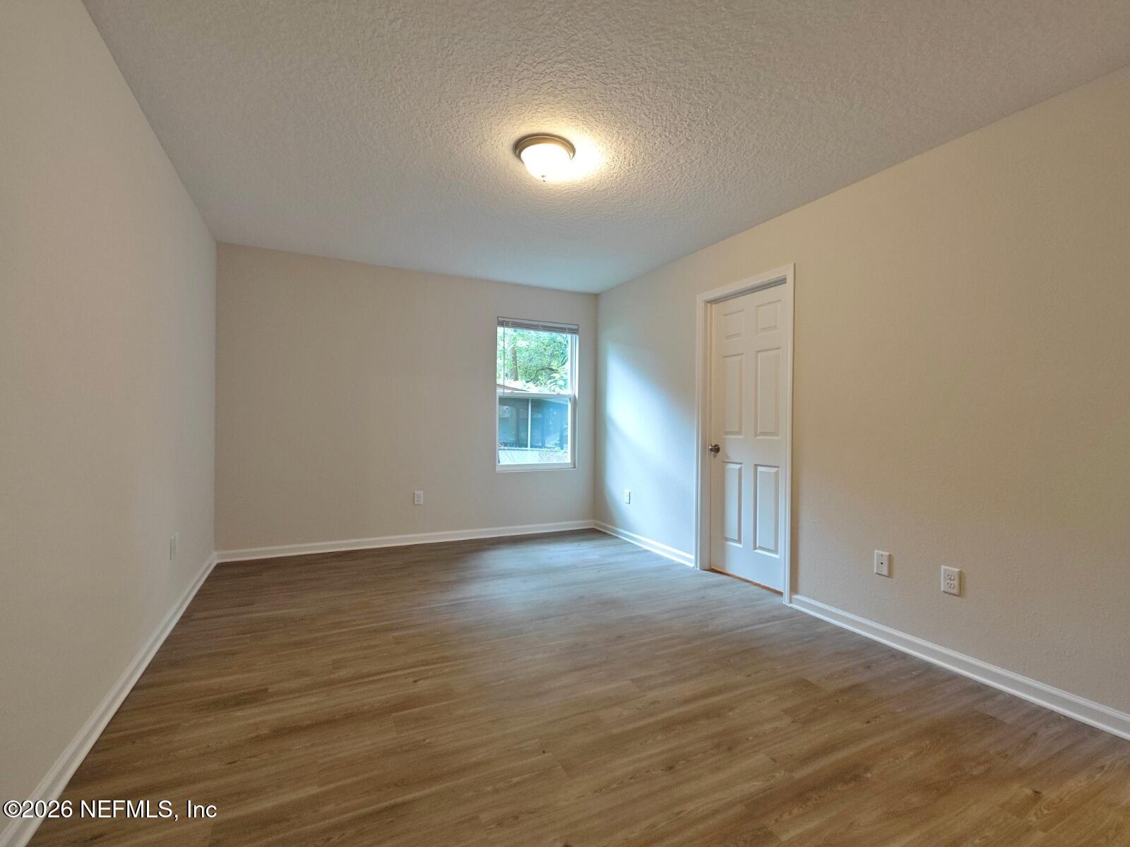 3142 Rosselle Street Jacksonville, FL 32205 - Photo 5 of 7 an empty room with wooden floor and windows