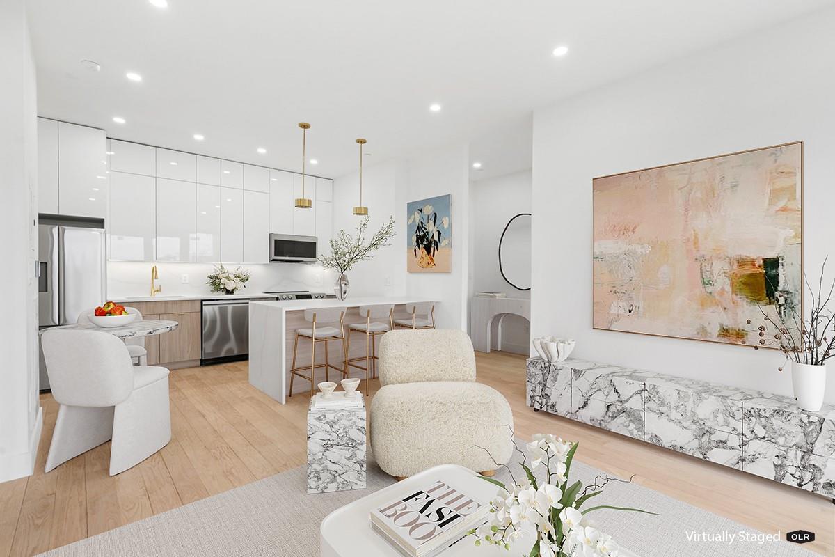 4529 47th Street, Unit 2B Queens, NY 11377 - Photo 3 of 6 a living room with furniture a table and kitchen view