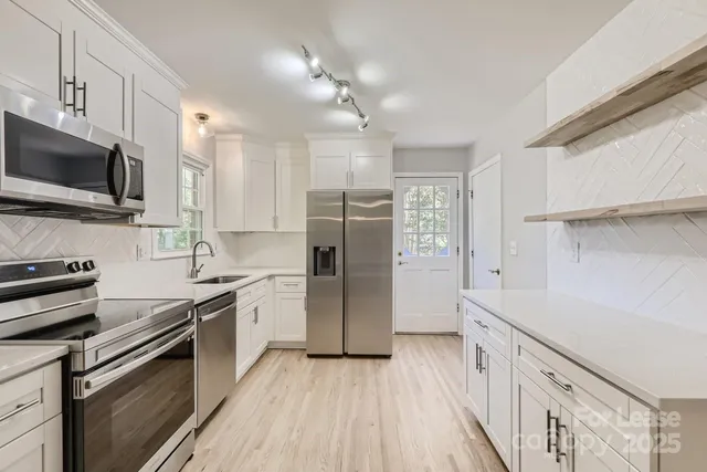 a kitchen with a sink a microwave a refrigerator and cabinets