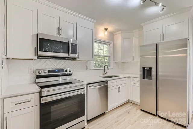 a kitchen with cabinets stainless steel appliances and a window