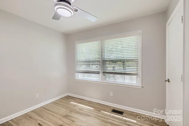 a view of a room with a window and wooden floor
