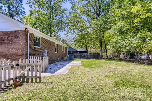 a view of a house with backyard and a tree