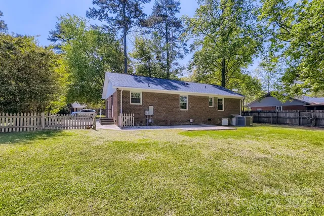 a view of a house with a yard and a patio