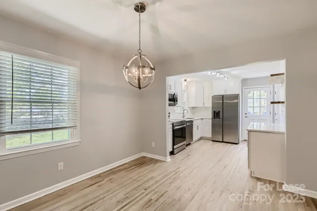 a open kitchen with stainless steel appliances granite countertop a stove refrigerator and microwave