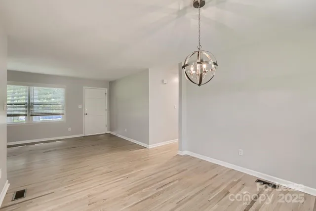 a view of a room with wooden floor fan and windows