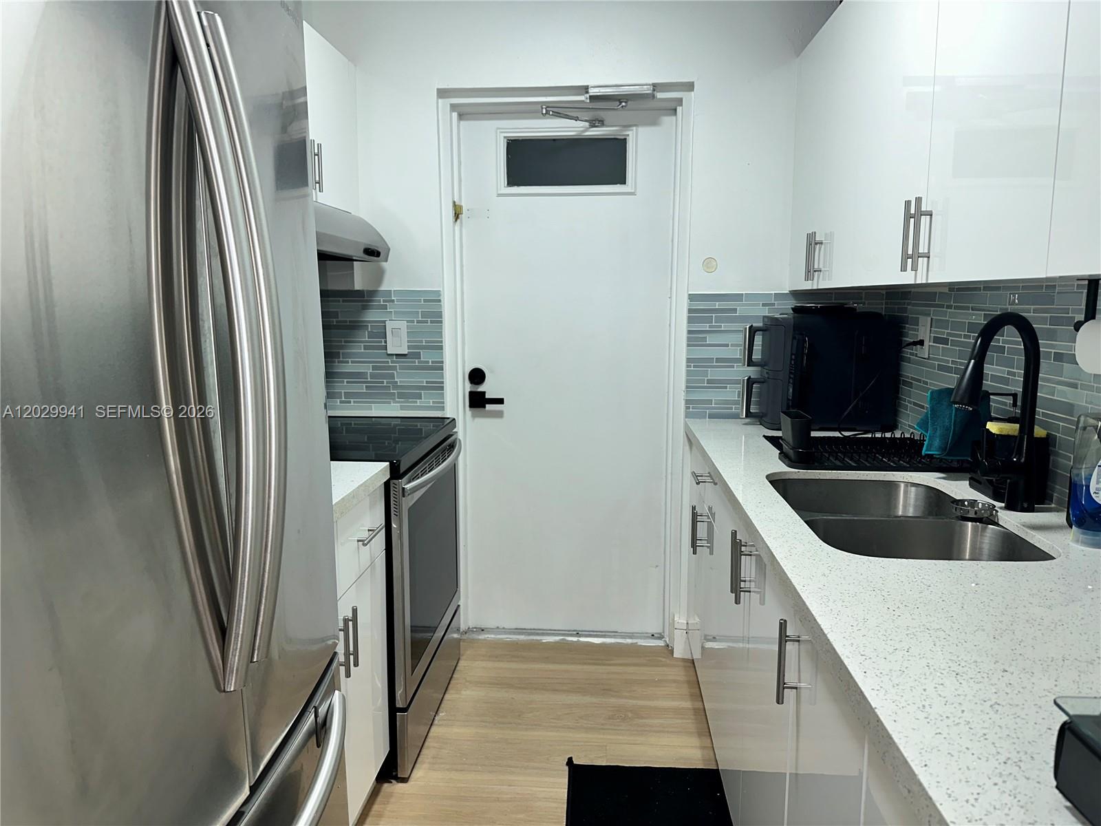 10900 Southwest 104th Street, Unit 107 Miami, FL 33176 - Photo 4 of 32 a kitchen with a refrigerator sink and white cabinets