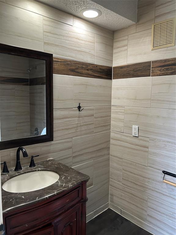 4107 Esters Road Irving, TX 75038 - Photo 21 of 21 Bathroom featuring a dark wood vanity with a stone countertop and an undermount sink top