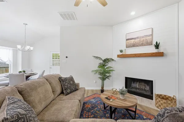 a living room with furniture a fireplace and a chandelier