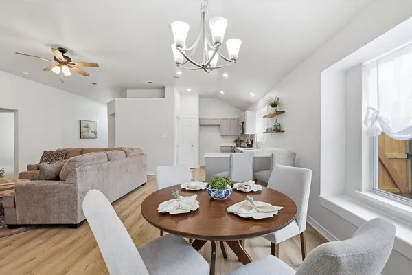 a living room with furniture kitchen view and a chandelier
