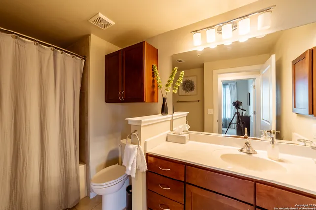 a bathroom with a sink vanity mirror and toilet