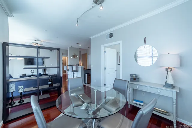 a dining room with wooden floor a chandelier a wooden table and chairs