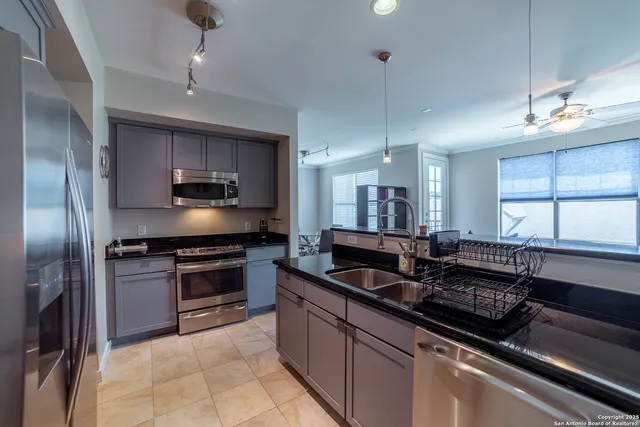 a kitchen with kitchen island granite countertop a sink stainless steel appliances and cabinets
