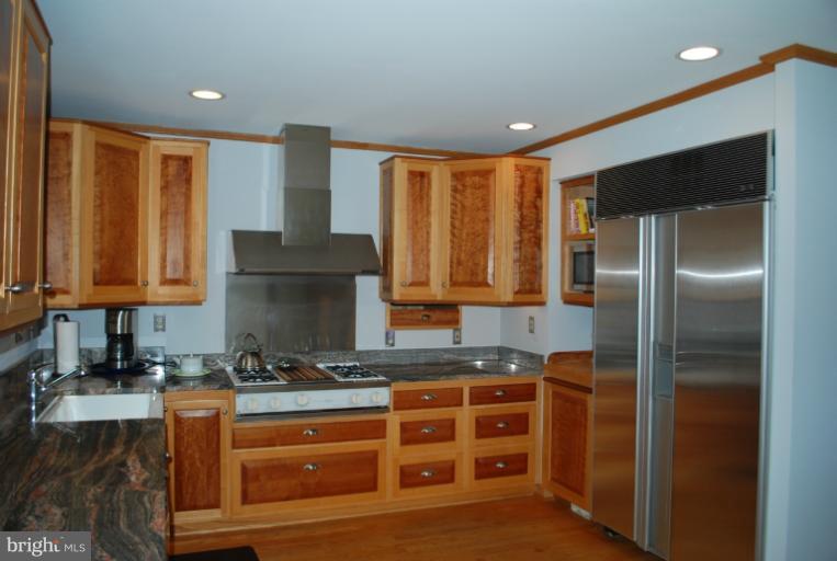 709 East Franklin Avenue Silver Spring, MD 20901 - Photo 5 of 9 a kitchen with stainless steel appliances granite countertop a refrigerator a stove and a sink with wooden floor