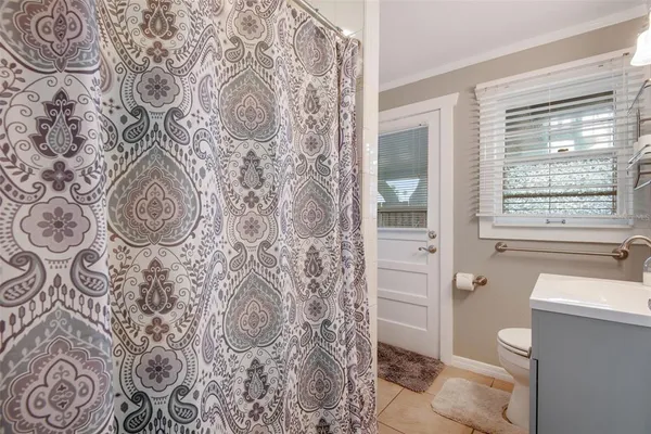 a bathroom with a toilet and a shower curtain