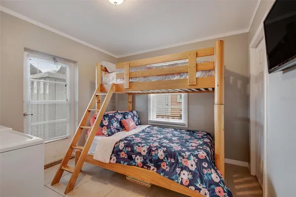a bedroom with a bed and a flat tv screen on the dresser