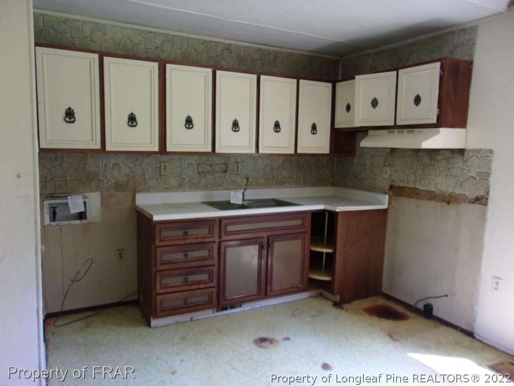 1877 H B Lewis Road Clinton, NC 28328 - Photo 3 of 10 a kitchen with stainless steel appliances granite countertop a sink and a stove