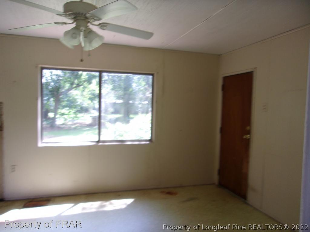 1877 H B Lewis Road Clinton, NC 28328 - Photo 4 of 10 an empty room with a window and a ceiling fan