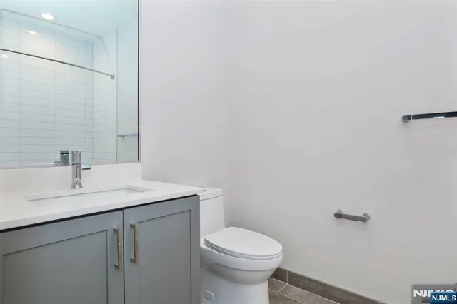 a bathroom with a sink a toilet and mirror