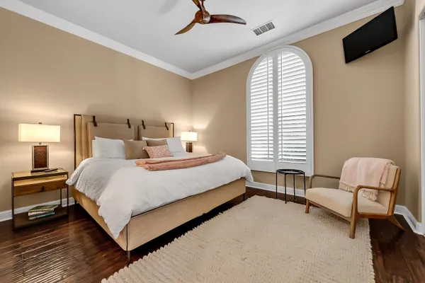 a bedroom with a bed chair and flat screen tv