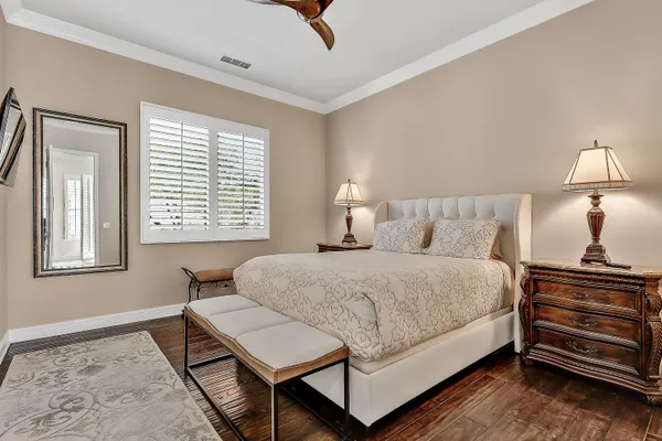 a bedroom with a bed a dresser and next to a window