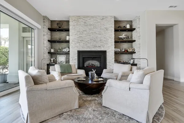 a living room with furniture a fireplace and a potted plant