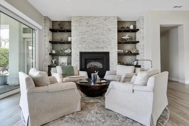 a living room with furniture a fireplace and a potted plant