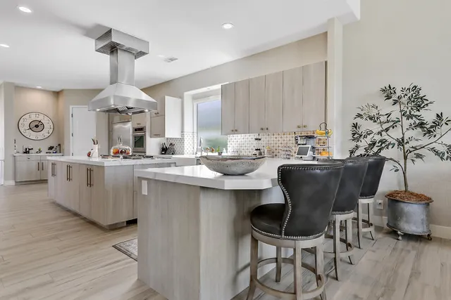 a kitchen with stainless steel appliances kitchen island a table and chair in it