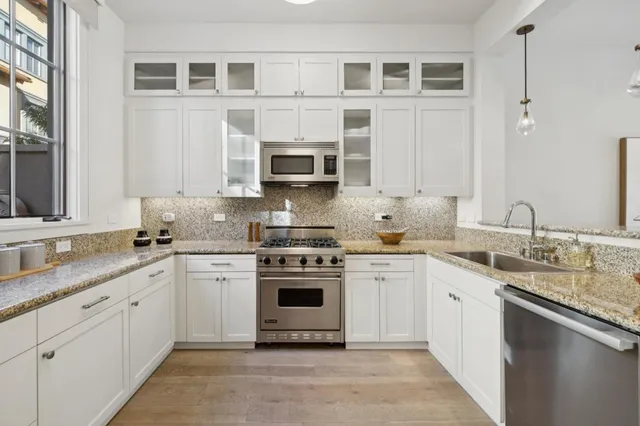 a kitchen with stainless steel appliances granite countertop a stove sink and cabinets