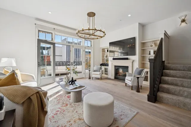 a living room with furniture a fireplace and a chandelier