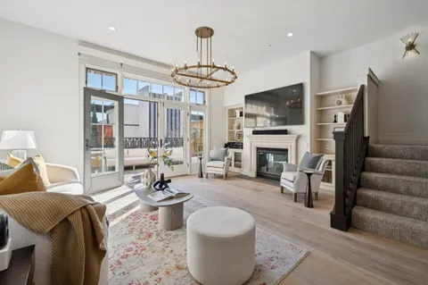 a living room with furniture a fireplace and a chandelier