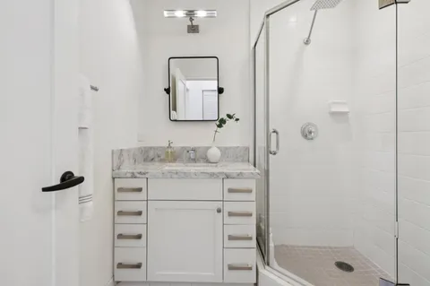 a bathroom with a shower sink and mirror