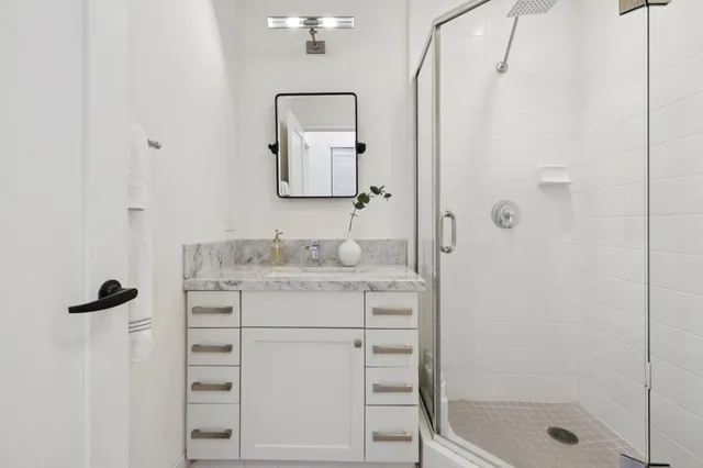 a bathroom with a shower sink and mirror