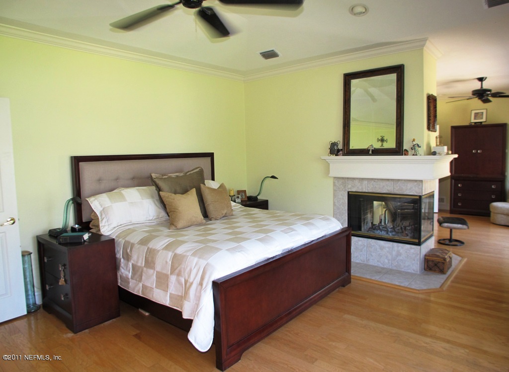 13120 Mandarin Road Jacksonville, FL 32223 - Photo 34 of 62 a bed sitting in a room next to a fireplace