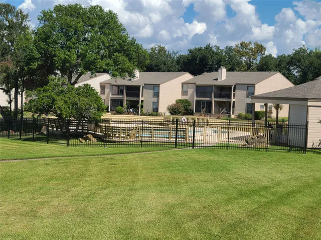 a green field with trees in the background