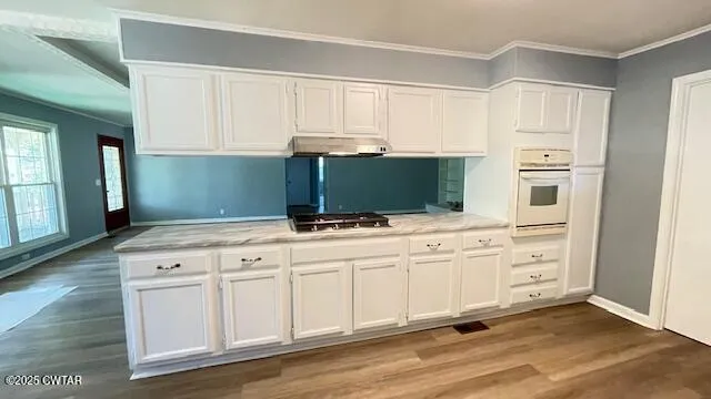 a kitchen with white cabinets and appliances