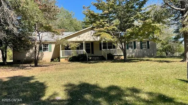 a front view of house with yard and trees around