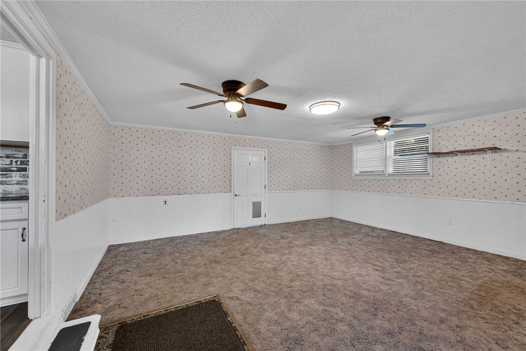 121 Wilson Road Anderson, SC 29625 - Photo 19 of 40 Patterned wallpaper and classic wainscoting frame this versatile carpeted room with double windows.