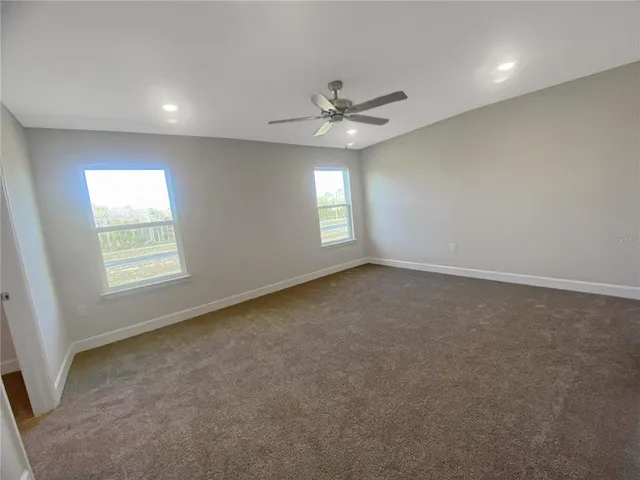 an empty room with a window and a ceiling fan
