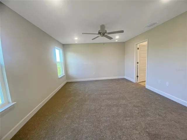 en empty room with windows and ceiling fan view