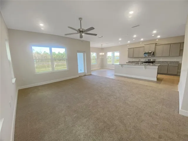 a large hall with a large window and stainless steel appliances