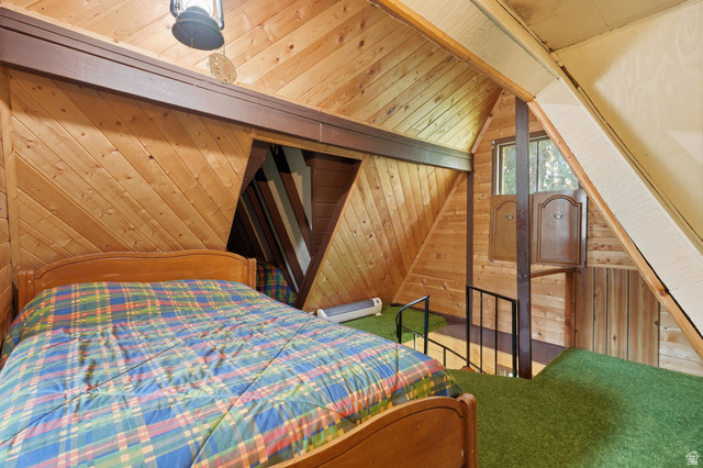 8505 South Snake Crk Road Salt Lake City, UT 84121 - Photo 31 of 67 Wood-paneled room featuring sloped walls, green carpeted flooring, and a metal railing