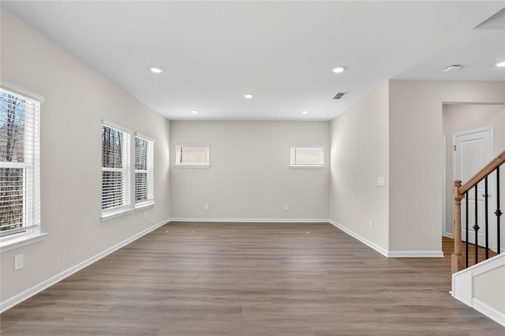 6929 Winchester Place Fairburn, GA 30213 - Photo 16 of 35 a view of an empty room with wooden floor and a window